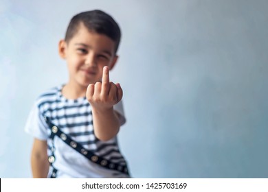 Six-year-old Boy Showing Middle Finger. 6-year Kid Hand Gesturing With His Middle Finger. Obscene Sign For A Negative Attitude.