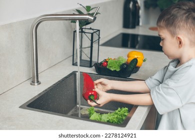 Six-year-old boy washing vegetables in the kitchen sink. Cooking and health care. Close-up.  - Shutterstock ID 2278124921