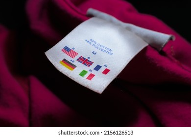 Size Tag Of A Red Cloth Describing  Different Country Size Comparisons 