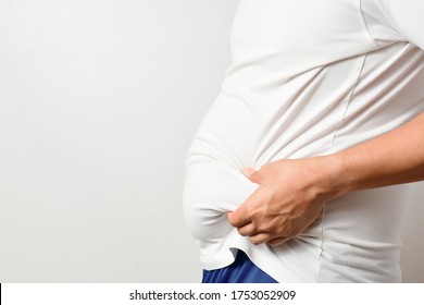 Size View Of Big Abdomen Asian Man In White T Shirt Grab His Stomach, Overweight Adult With Copy Space. Fat Man With Belly Cause Obesity.