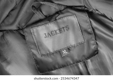 Size XL clothes patch label text Jackets closeup as a background