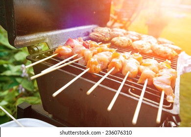 Sizzling Burgers And Chicken Kebabs On Hot Barbecue Outdoor In The Evening Sun.