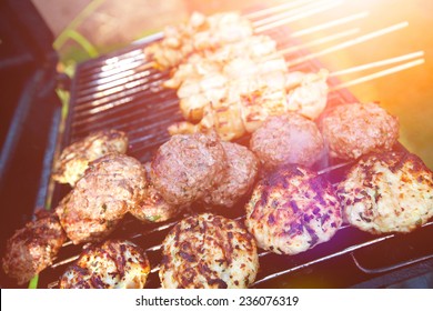 Sizzling Burgers And Chicken Kebabs On Hot Barbecue Outdoor In The Evening Sun.