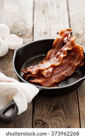 Sizzling Hot Bacon Pieces In A Cast Iron Skillet