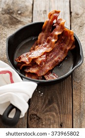 Sizzling Hot Bacon Pieces In A Cast Iron Skillet