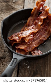 Sizzling Hot Bacon Pieces In A Cast Iron Skillet