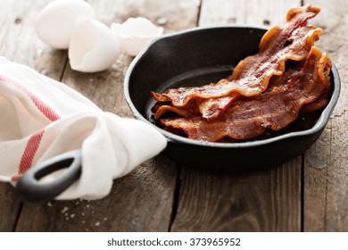 Sizzling Hot Bacon Pieces In A Cast Iron Skillet