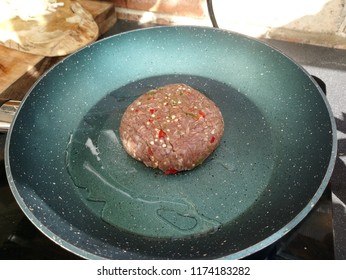 Sizzling Raw Turkey Burger With Seasoning On A Hot Frying Pan 