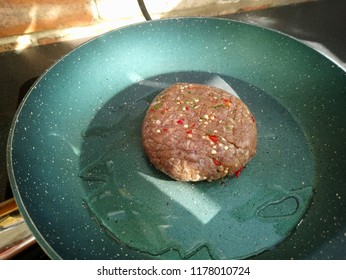 Sizzling Raw Turkey Burger With Seasoning On A Hot Frying Pan 