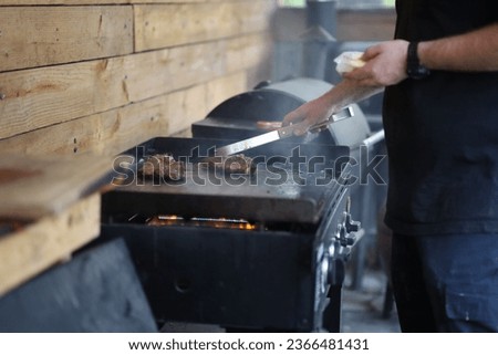 Similar – Man cooking on a barbecue