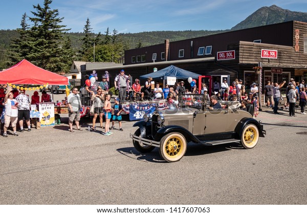 Skagway, Alaska /\
United States - July 4 2018: Fourth of July Parade with antique car\
passing the reviewing\
stand