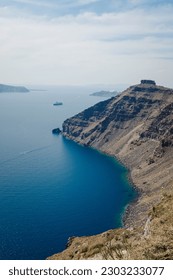 Skaros Rock, the ancient fortress ruins in Imerovigli, Santorini, stand against the backdrop of a mesmerizing blue sea and sky.