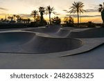 Skate park at sunrise with palm trees and orange sky