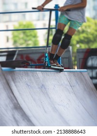 Skate Park View With Kids On A Kick Scooter Doing Tricks And Stunts, Boys In A Skate Park Riding Bmx Bike And Skate, Playing And Enjoying Summer On New Ramp, Teenagers Skateboarders And Bmx Riders 