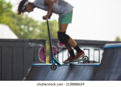 Skate Park View With Kids On A Kick Scooter Doing Tricks And Stunts, Boys In A Skate Park Riding Bmx Bike And Skate, Playing And Enjoying Summer On New Ramp, Teenagers Skateboarders And Bmx Riders 