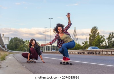 Skateboard girls riding longboards down the road