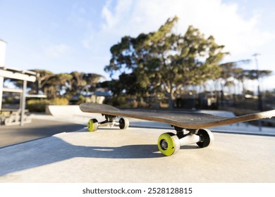 Skateboard resting on ledge at outdoor skate park on sunny day, copy space. Skateboarding, sports, urban, recreation, unaltered - Powered by Shutterstock