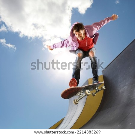 Skateboarder doing a jumping trick. Extreme sports concept on sky background