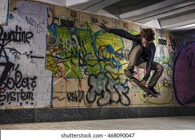 Skateboarder doing a skateboard trick against graffiti wall - Powered by Shutterstock