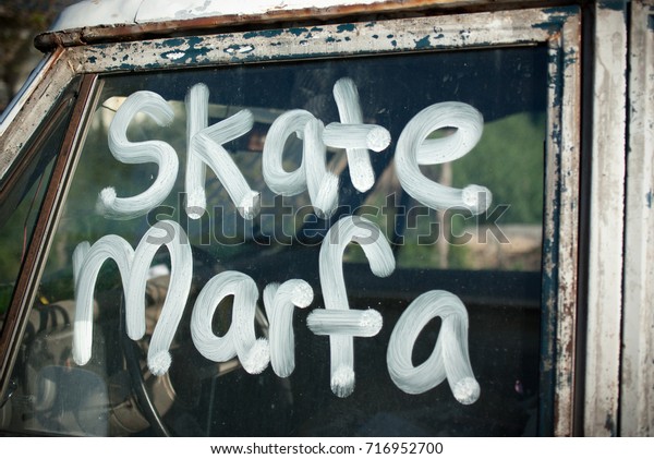 Skateboarder\
graffiti on an old car in Marfa,\
Texas.