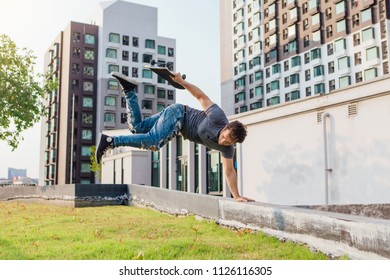 Skateboarder Handstand On Ramp On The Sunset.