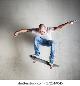 Skateboarder Jumping Against Concrete Wall. 