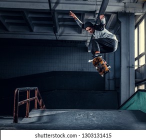 Skateboarder Jumping High On Mini Ramp At Skate Park Indoor.