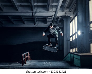 Skateboarder Jumping High On Mini Ramp At Skate Park Indoor.