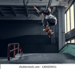 Skateboarder jumping high on mini ramp at skate park indoor. - Powered by Shutterstock