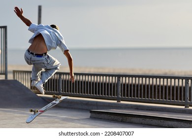 Skateboarder Jumping In A Skatepark By The Beach