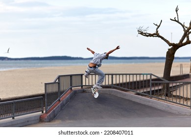 Skateboarder Jumping In A Skatepark By The Beach