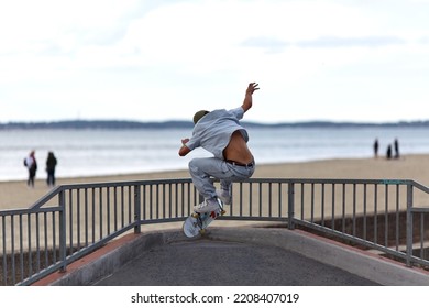 Skateboarder Jumping In A Skatepark By The Beach