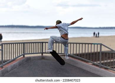 Skateboarder Jumping In A Skatepark By The Beach