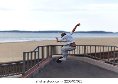 Skateboarder Jumping In A Skatepark By The Beach