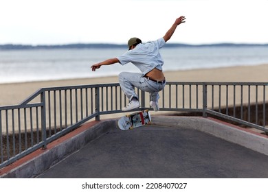 Skateboarder Jumping In A Skatepark By The Beach