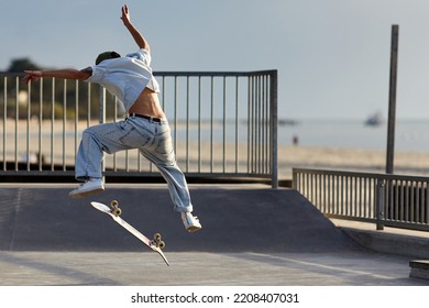 Skateboarder Jumping In A Skatepark By The Beach