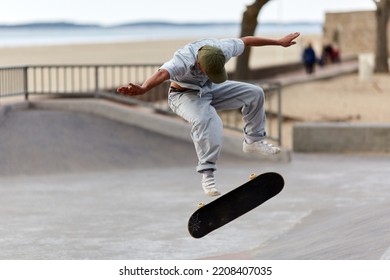 Skateboarder Jumping In A Skatepark By The Beach