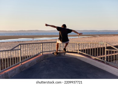 Skateboarder Jumping In A Skatepark By The Beach