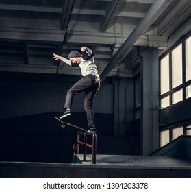 Skateboarder Performing A Trick On Mini Ramp At Skate Park Indoor.