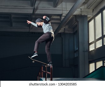 Skateboarder Performing A Trick On Mini Ramp At Skate Park Indoor.