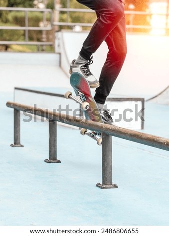 Similar – Image, Stock Photo Skateboarder performing a trick on a rail at a skatepark.