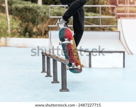 Image, Stock Photo Skateboarder performing a trick on a rail at a skatepark.