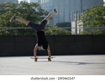 Skateboarder Practice Handstand On Skateboard At City