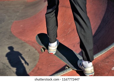 Skateboarder ready to roll. Image shows boy has feet on skateboard about to go down metal edge. Image shows legs, skateboard and person's shadow. - Powered by Shutterstock