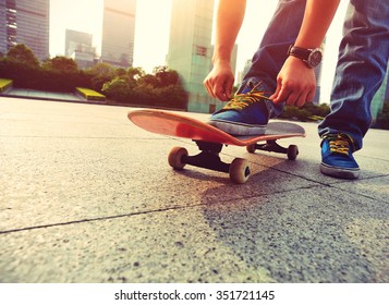 skateboarder tying shoelace at city - Powered by Shutterstock