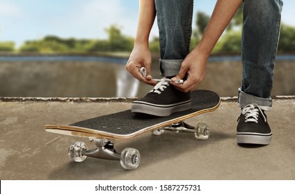 Skateboarder tying shoes at skate park - Powered by Shutterstock