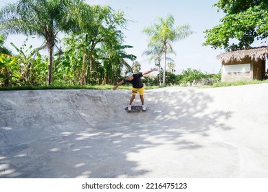 Skateboarder Wearing Yellow Shorts Riding In Bowl Skate Park.