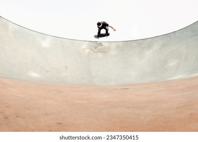 skateboarding at a skatepark grinding a pool on a skateboard
