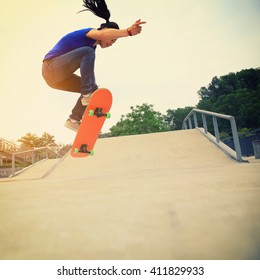 Skateboarding Woman Practice Ollie At Skatepark