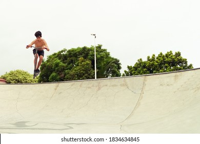 Skater Boy Training In City Skate Park Outdoor . Young Trendy Man Performing Skills And Tricks With Special Kick Scooter. Extreme Sport Concept - Image